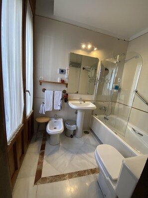 Tweepersoonskamer | Badkamer | Een diep bad, een haardroger, een bidet, handdoeken