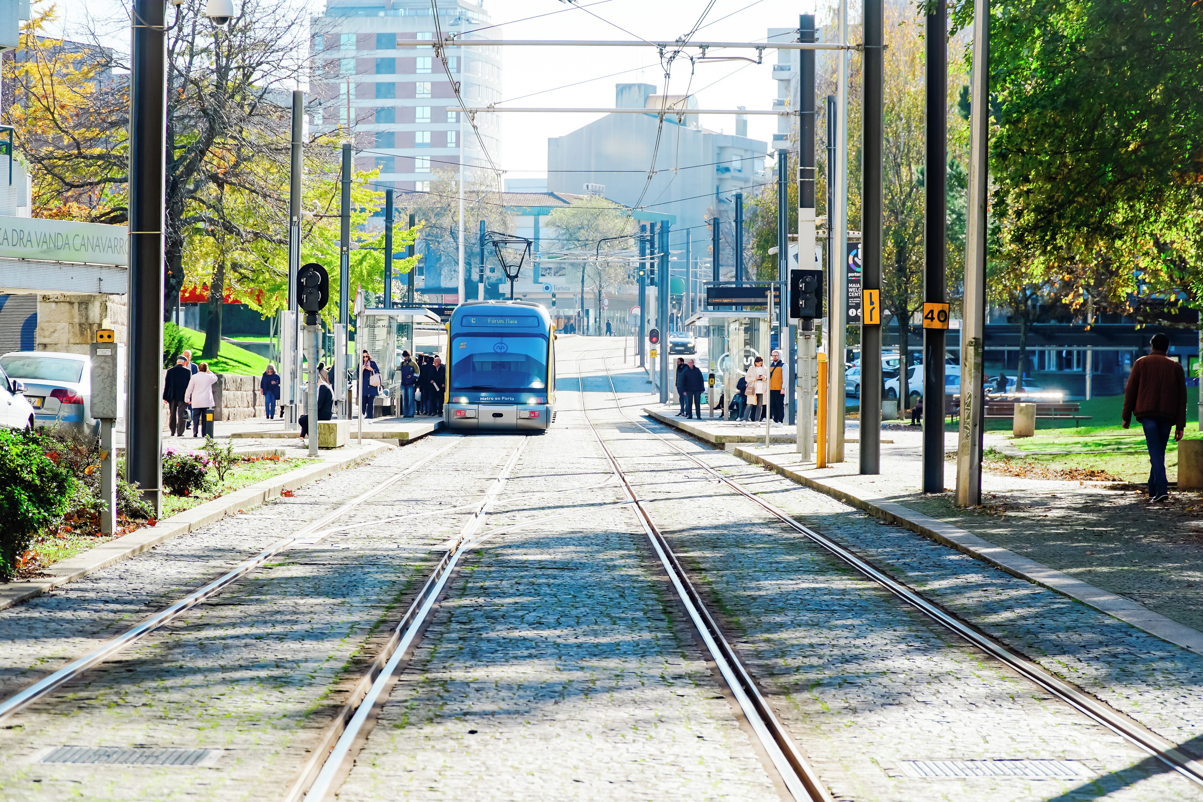 Un tramway dans une station dotée de plusieurs voies, de câbles aériens et d’un quai.