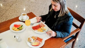A person dining at a table with breakfast plates, a glass of orange juice, and a cup of coffee. - Premium Porto Maia (Maia)