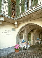 Un café con terraza, paredes de piedra y un letrero que dice "REMAT CAFÉ-RESTO GARDIA".