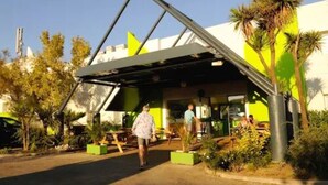 Un bâtiment moderne doté d’un toit en pente et d’un espace d’entrée abrité.