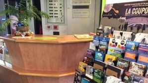 Un comptoir d’accueil avec un revêtement en bois, entouré de brochures et de documents d’information.