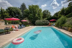 Una piscina al aire libre, tumbonas