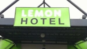Señal del Hotel Lemon, con fondo verde y letras blancas.