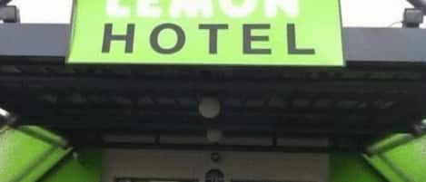 Une enseigne pour l’hôtel Lemon, avec un fond vert et des lettres blanches.