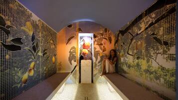 Guests can relax in a tranquil corridor with a mosaic-patterned wall and a comfortable bench.