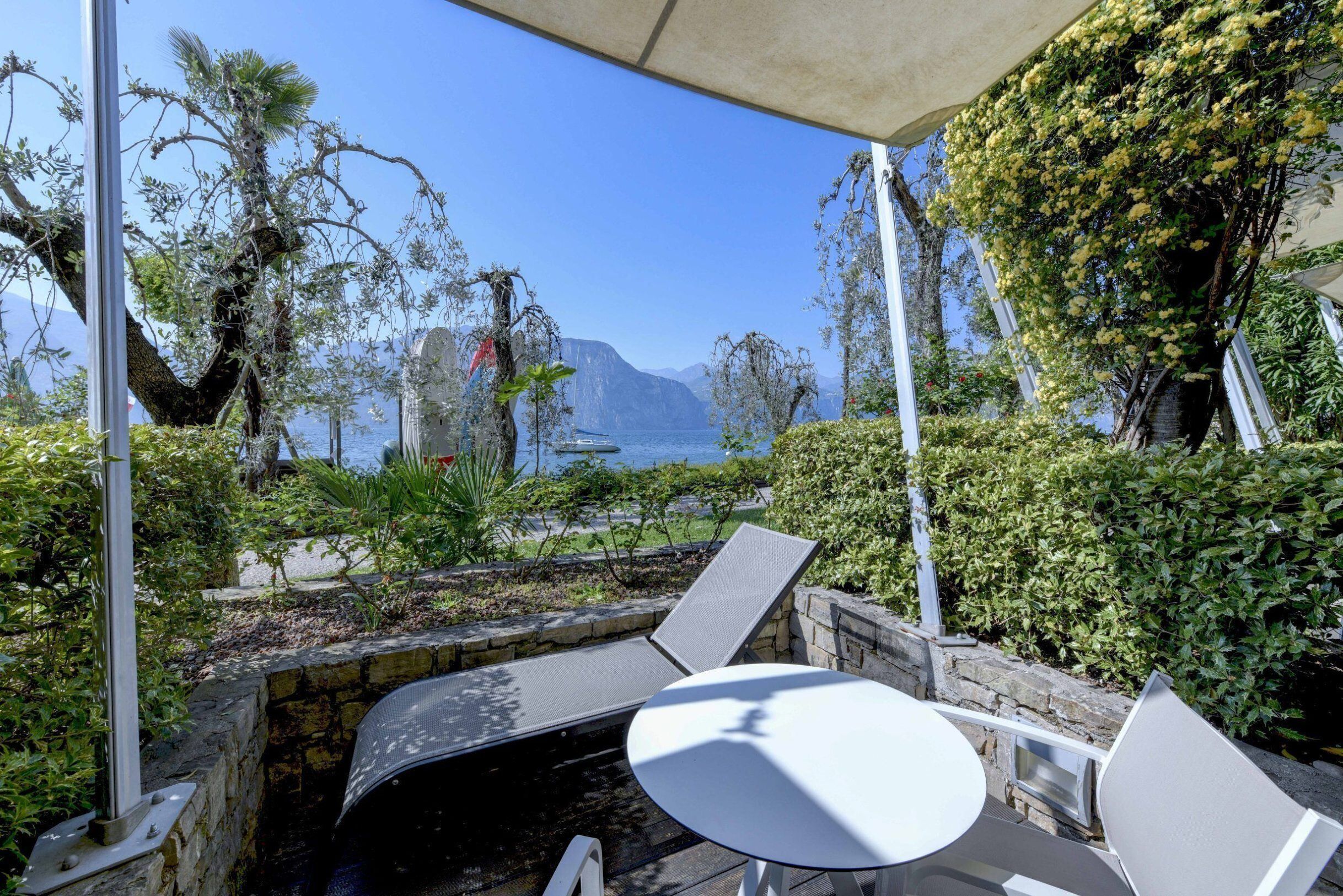 An outdoor seating area with a view of the sea and mountains.
