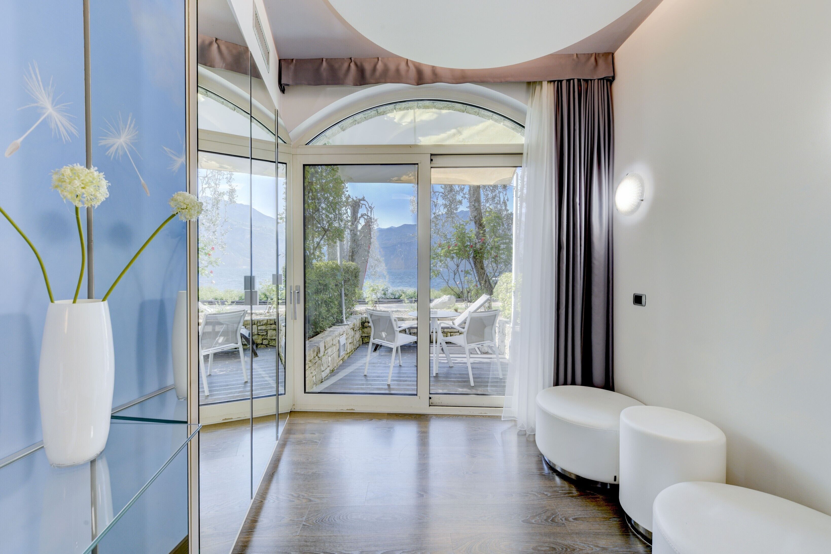 Ein modernes Interieur mit einer Glastür, die zu einem Sitzbereich im Freien führt.