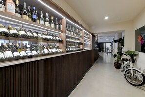 Eine Weinbar mit Regalen voller Weinflaschen und einem Motorrad im Vintage-Stil im Hintergrund.