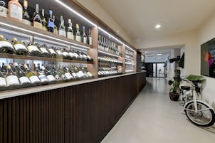 A wine bar with shelves of wine bottles and a vintage motorcycle in the background.