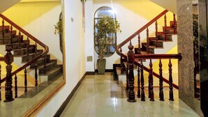 A grand staircase with wooden balusters and a polished floor leading to a landing. - La Suisse Hotel (Nha Trang)