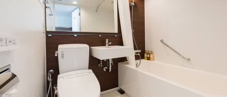 A modern bathroom with a toilet, sink, and bathtub.