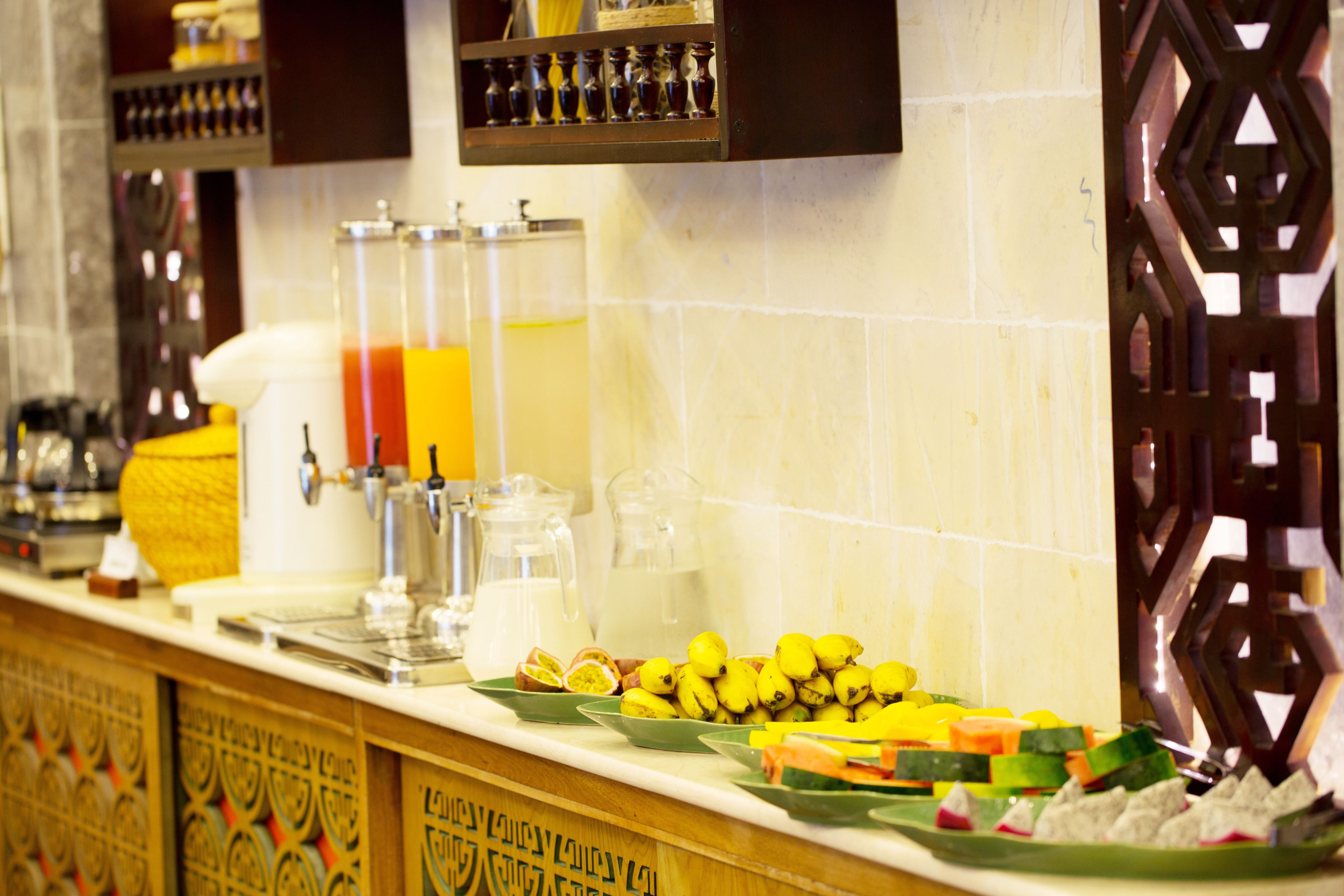 A buffet counter with various food items and beverages.