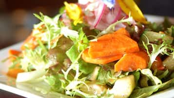 Primer plano de una ensalada con diversas verduras y hojas verdes.