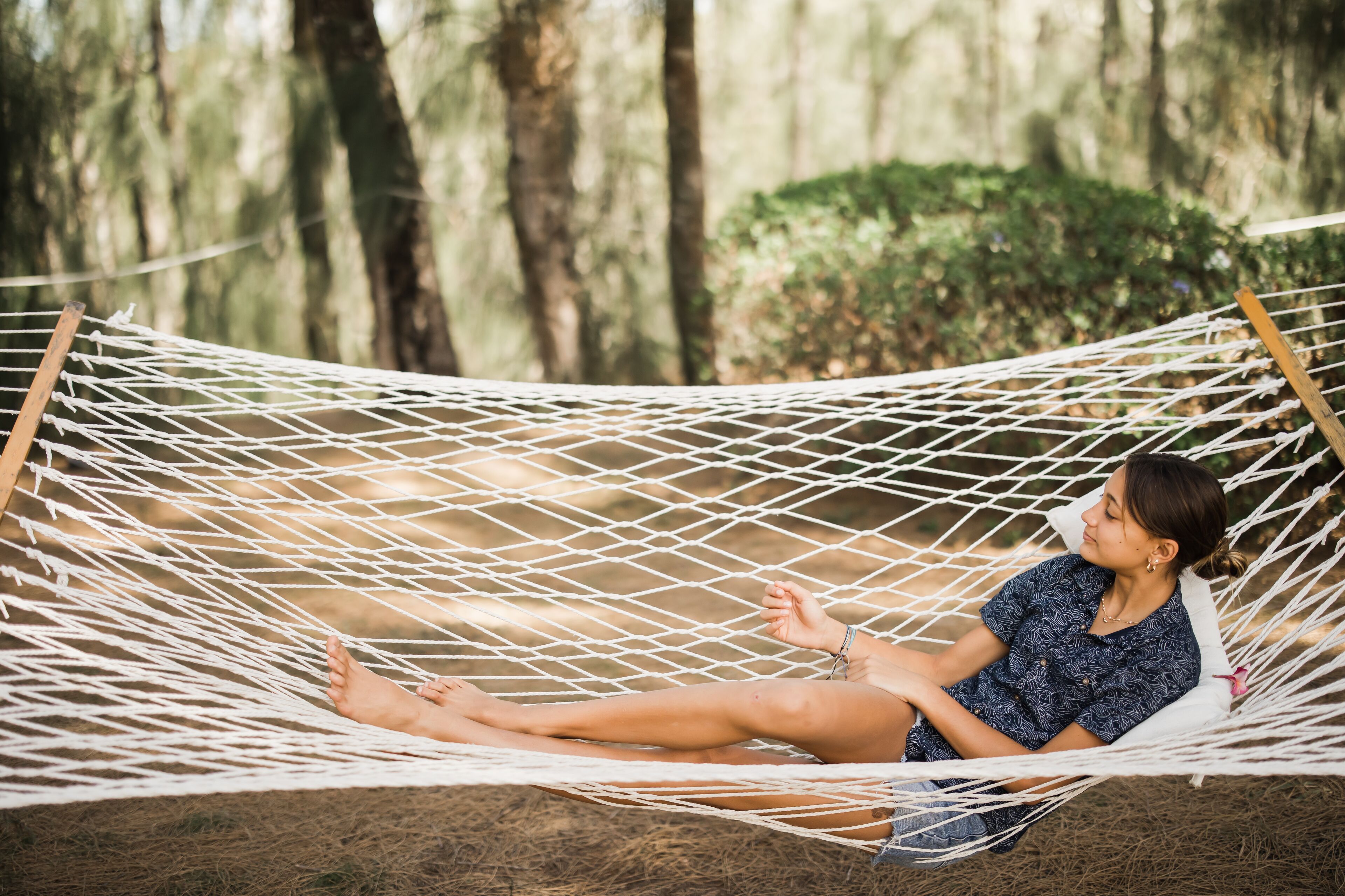 A hammock in a natural setting with trees in the background.