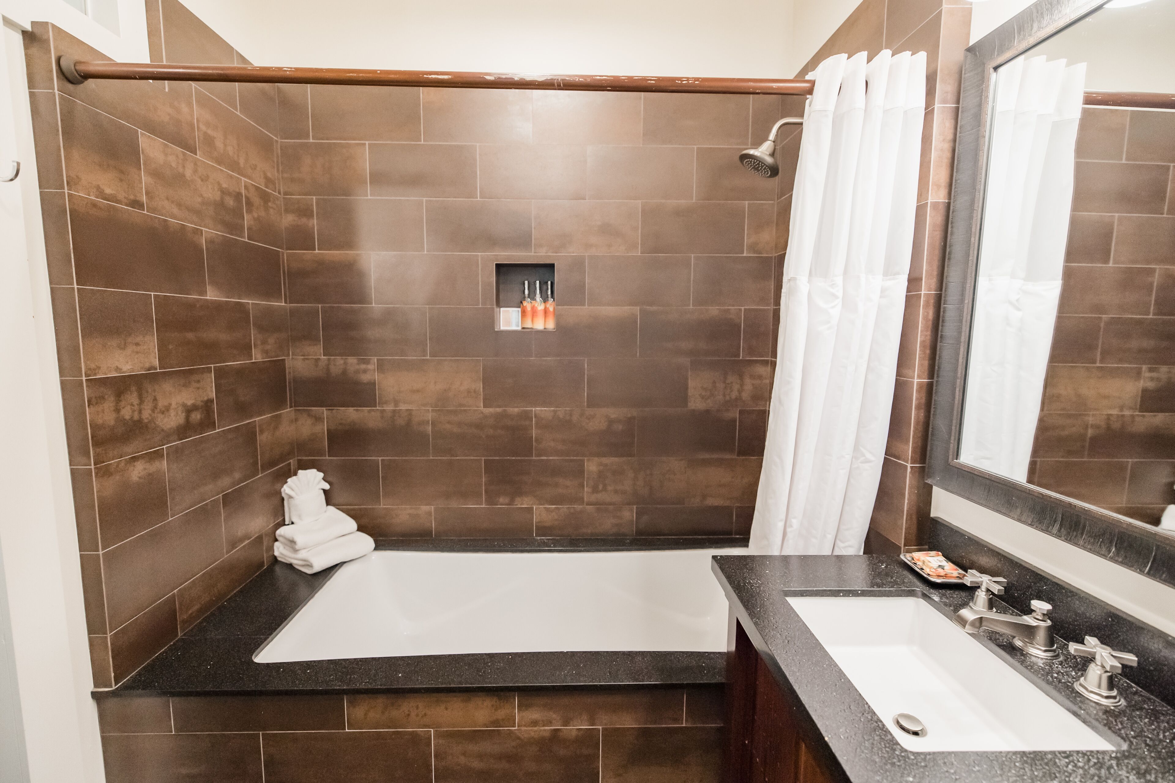 A modern bathroom with a bathtub, a sink, and a shower.