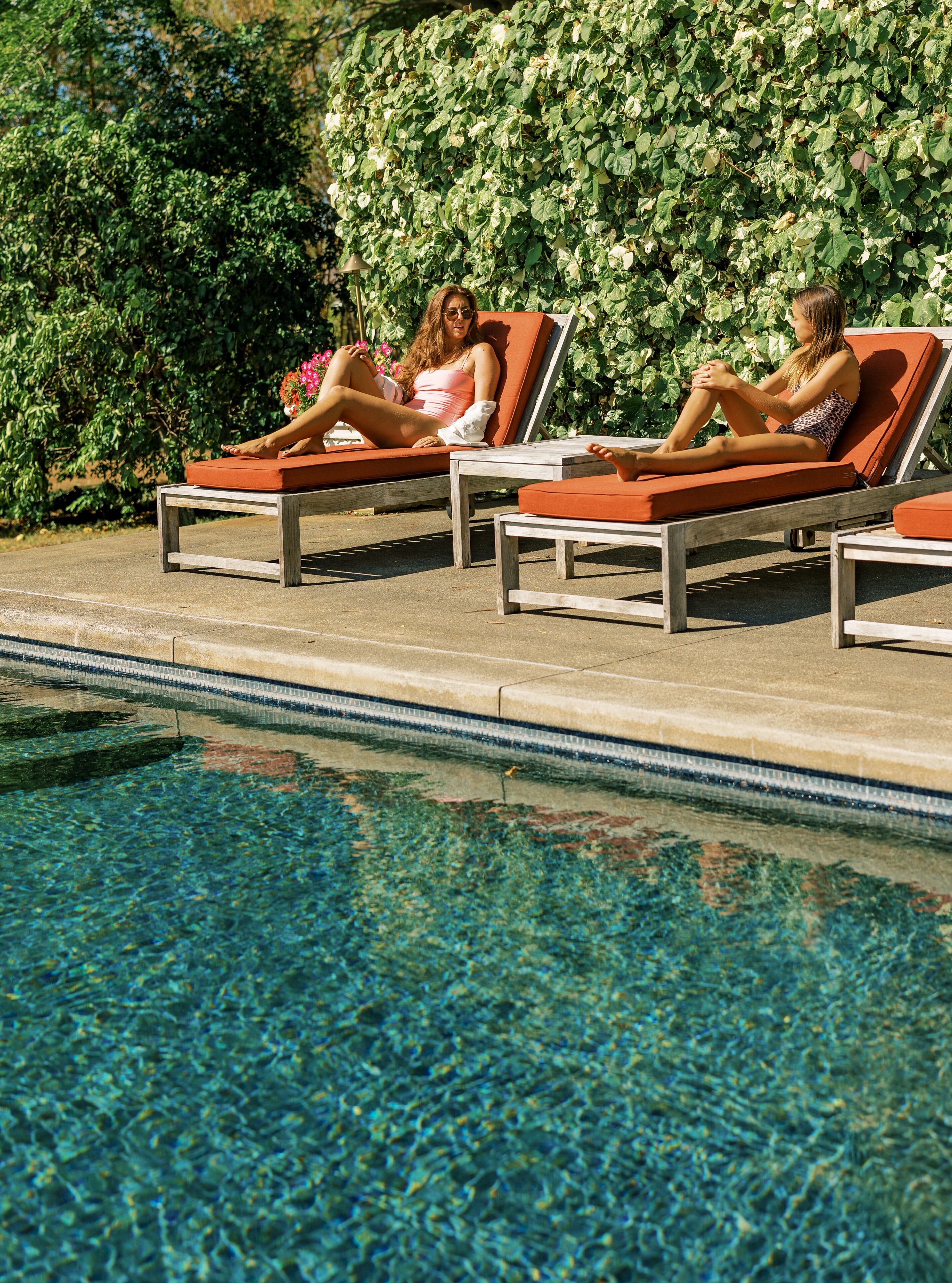 A poolside area with lounge chairs and a clear pool.