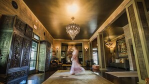 A spacious lobby with a large chandelier, wooden paneling, and a central rug.