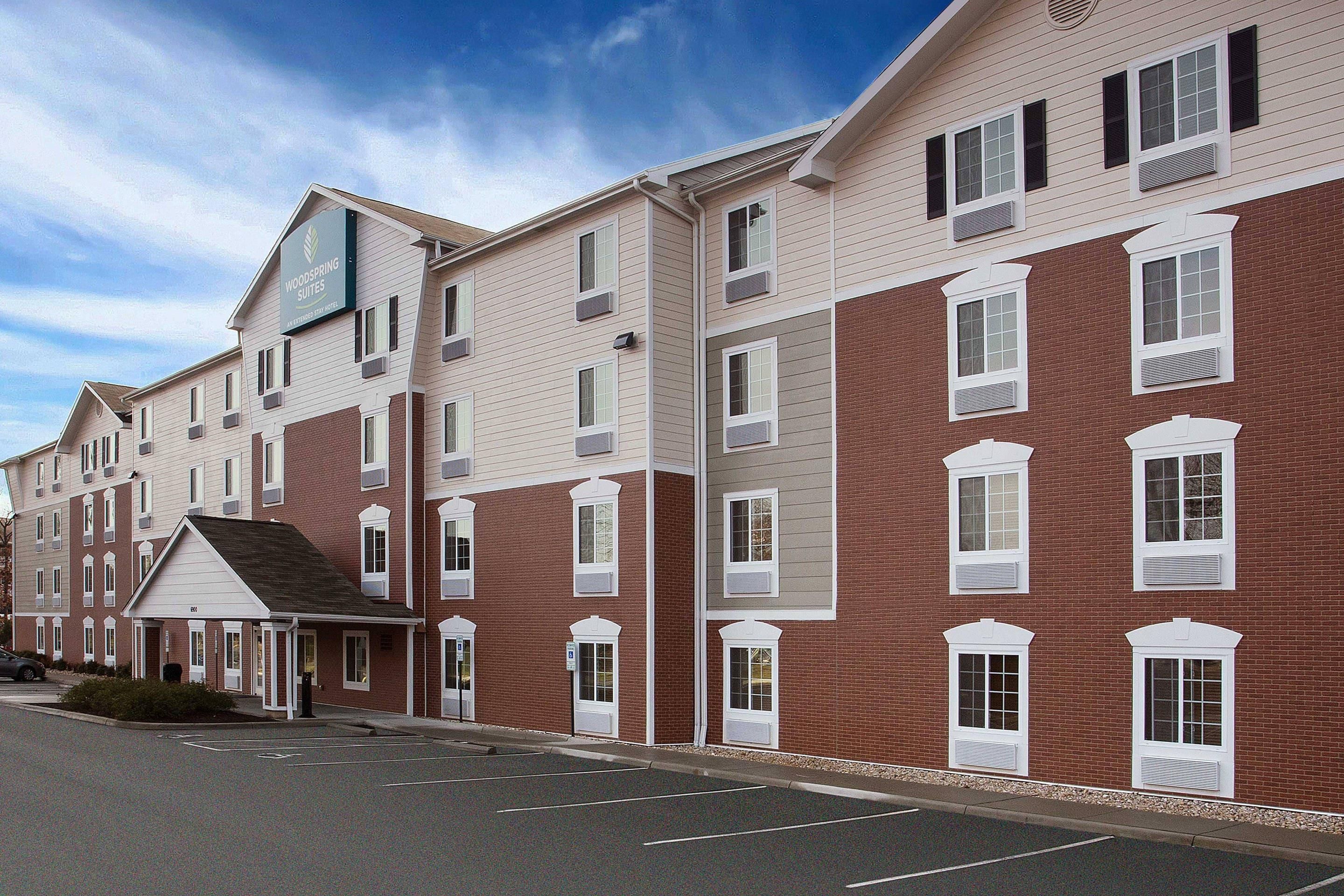 A multi-story hotel with a brick facade, multiple windows, and a clear sky.