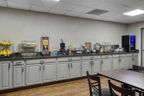 A breakfast bar with a coffee machine, a fruit basket, and a microwave.