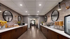 Una cocina moderna con armarios de madera, una isla central con alimentos y una encimera larga con varios recipientes de comida.