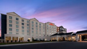 A large hotel with multiple floors, a prominent sign, and a well-lit entrance. - Hilton Garden Inn Salt Lake City Airport (Salt Lake City)