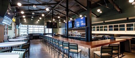 A spacious indoor seating area with high ceilings and multiple tables and chairs.