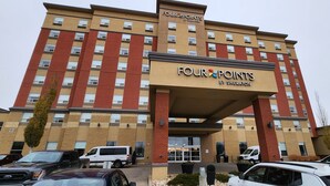Un hotel de varios pisos con un llamativo letrero de 'Four Points by Sheraton'.