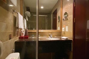 A bathroom with a glass partition, a sink, a toilet, and a mirror. - Fuling Hotel (Chongqing)