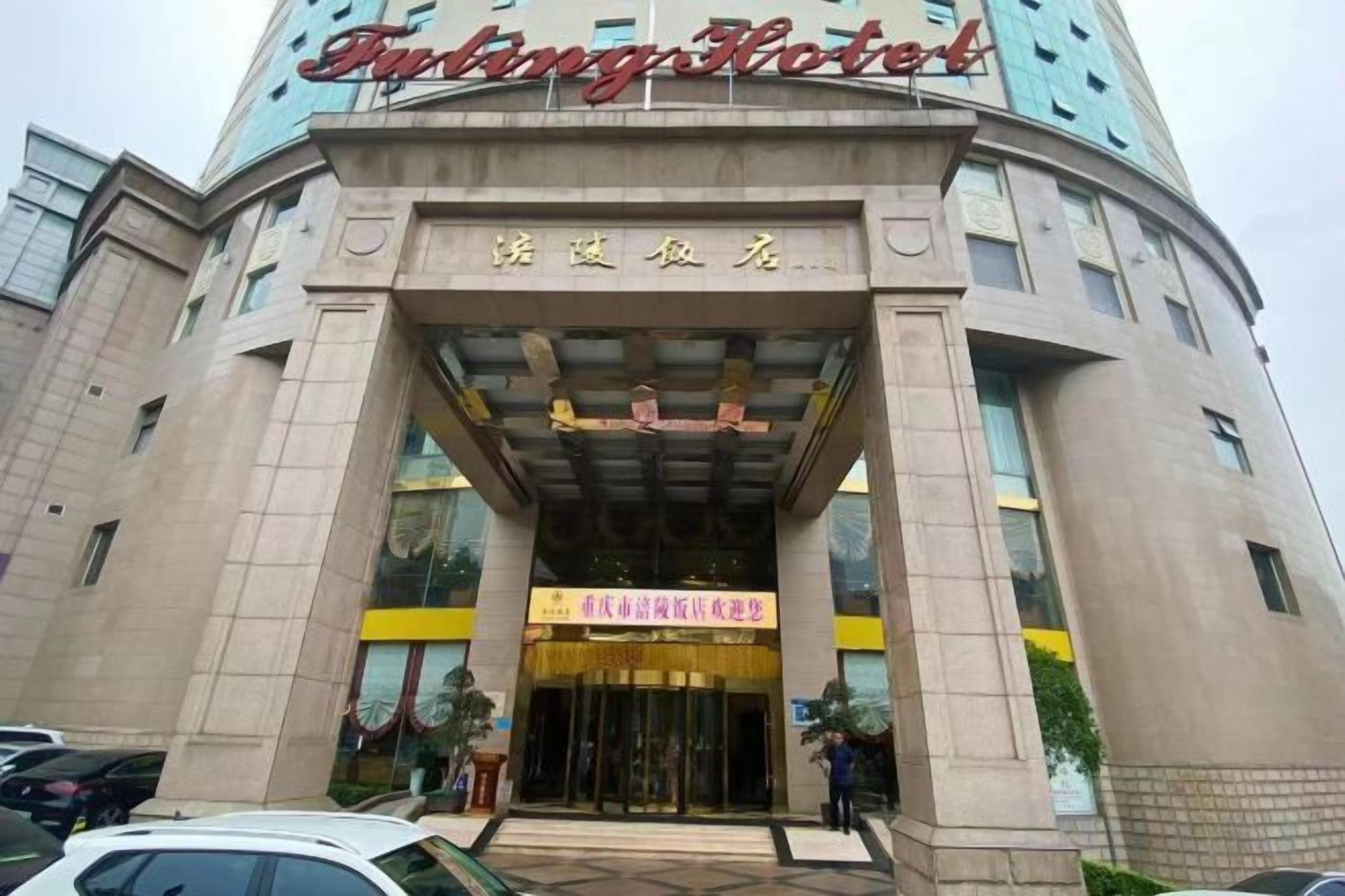 Entrada de hotel com um letreiro chamativo, cobertura e porta visível.