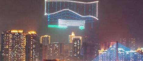 A cityscape at night with illuminated buildings and a bridge.