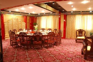 A conference room with a round table, multiple chairs, and a carpeted floor.