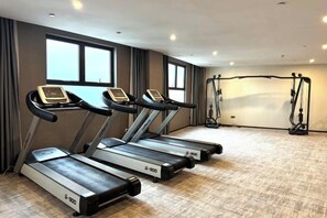 A fitness room with treadmills and a weight machine.