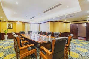 A conference room with a large oval table, multiple chairs, and a carpeted floor. - Fuling Hotel (Chongqing)