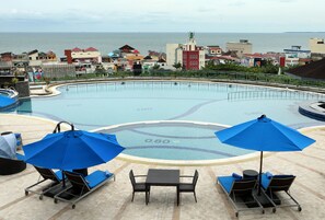 Una piscina al aire libre, sillones reclinables de piscina