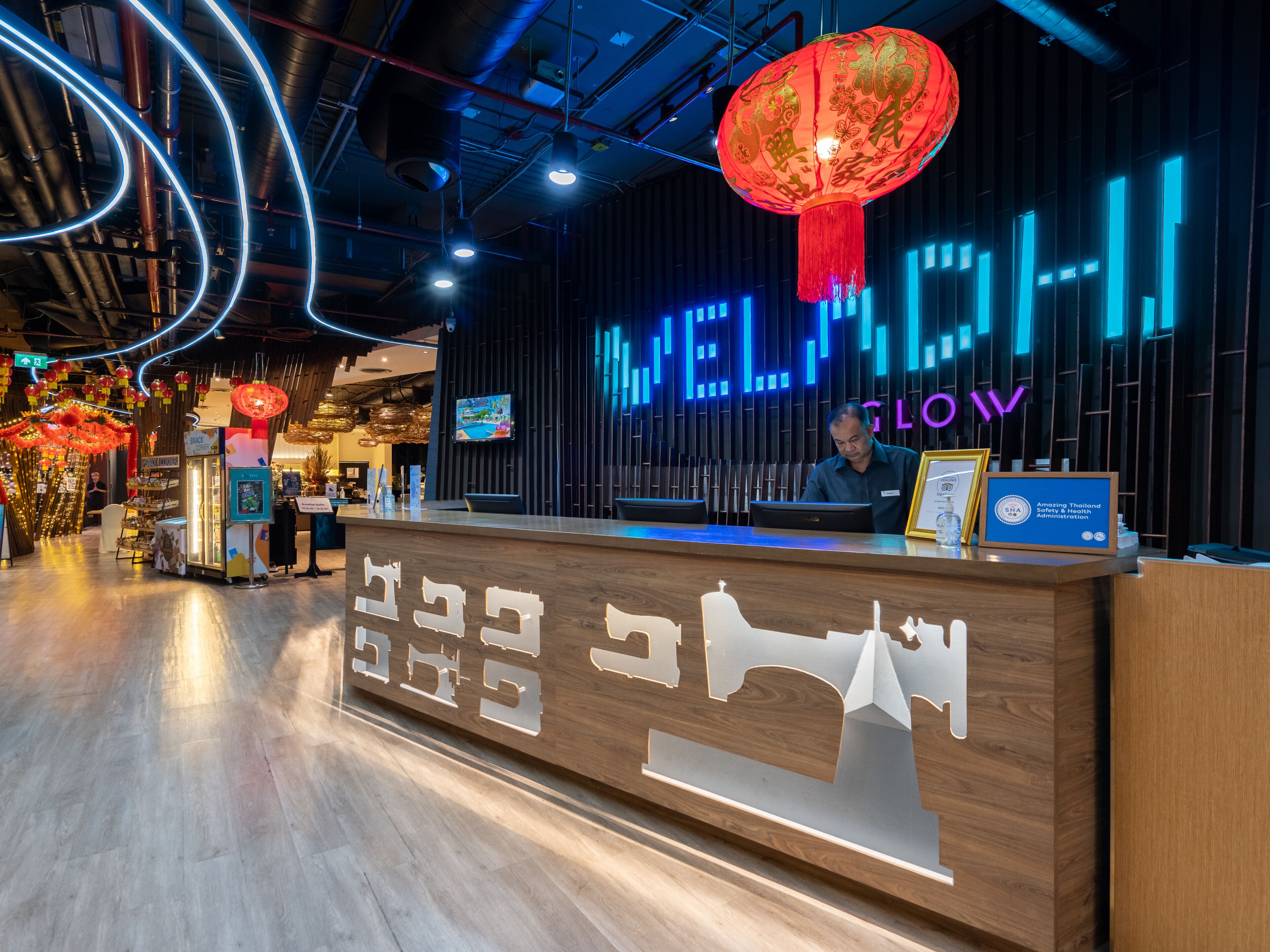Ein moderner Empfangstresen mit einem Neonlichtschild mit der Aufschrift 'WELCOME IV LLOY'.
