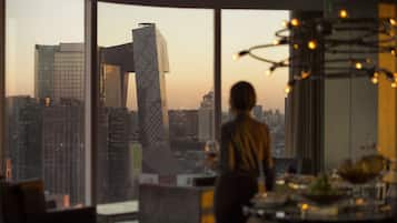 A modern interior with large windows offering a cityscape view, including a distinctive building with a unique design.