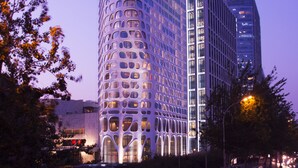 A modern hotel with a unique curved facade and large windows. - Conrad Beijing (Beijing)