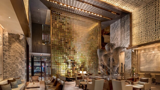 A spacious lobby with a high ceiling, modern seating arrangements, and a large abstract sculpture. - Conrad Beijing (Beijing)