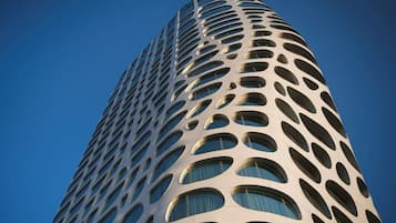 En høj bygning med et unikt arkitektonisk design og mange ovale vinduer.