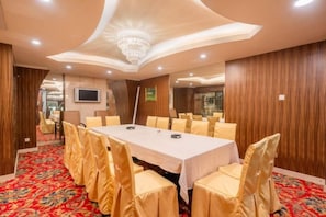 A conference room with a long table, chairs, and a chandelier. - Hotel de Royce (Shaoguan)