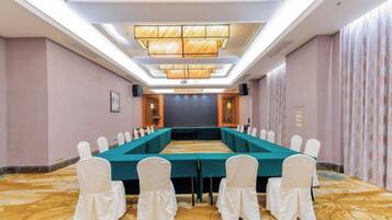 A conference room with a long table, chairs, and a chandelier.