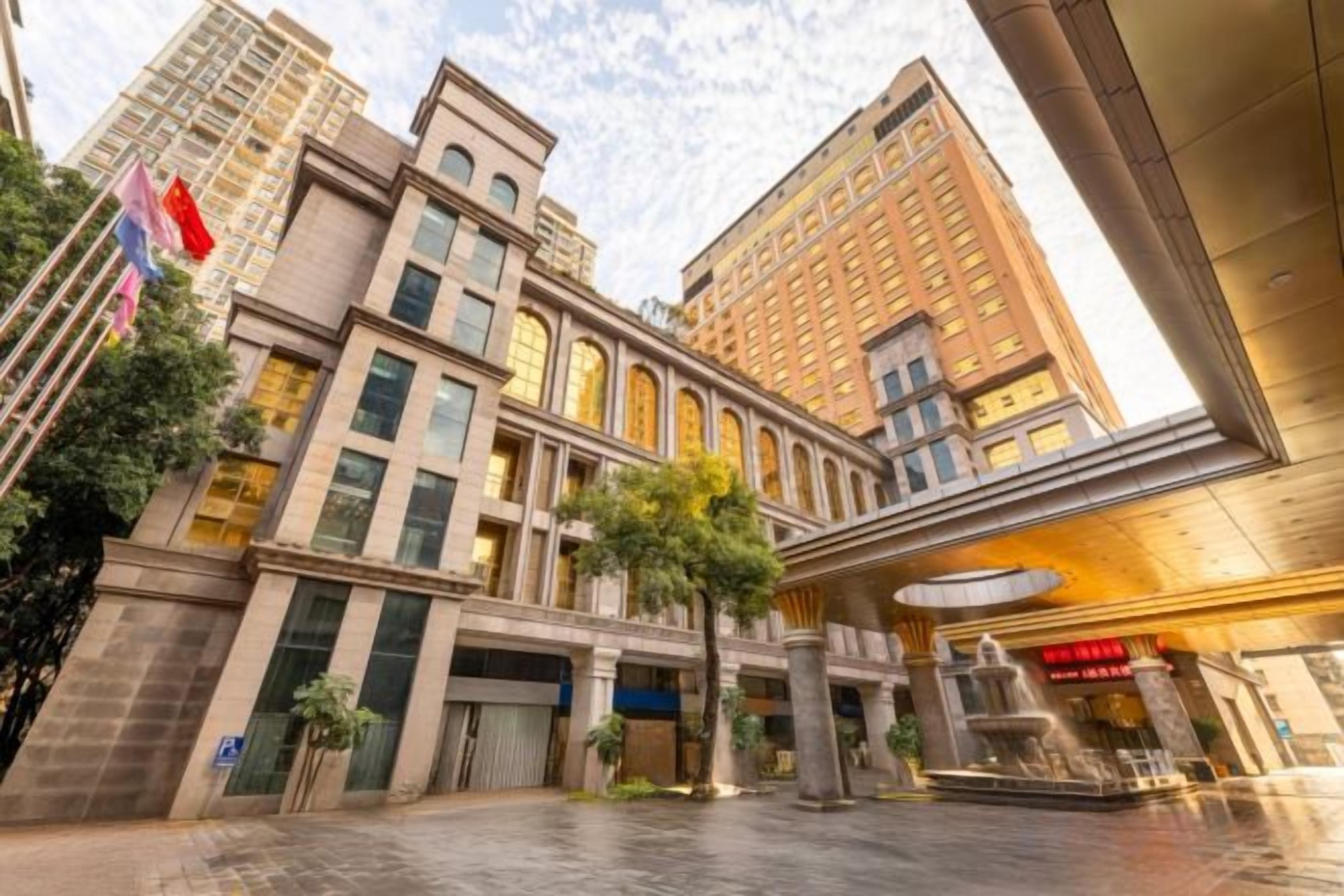 A multi-story hotel with a central courtyard, large windows, and a prominent entrance.