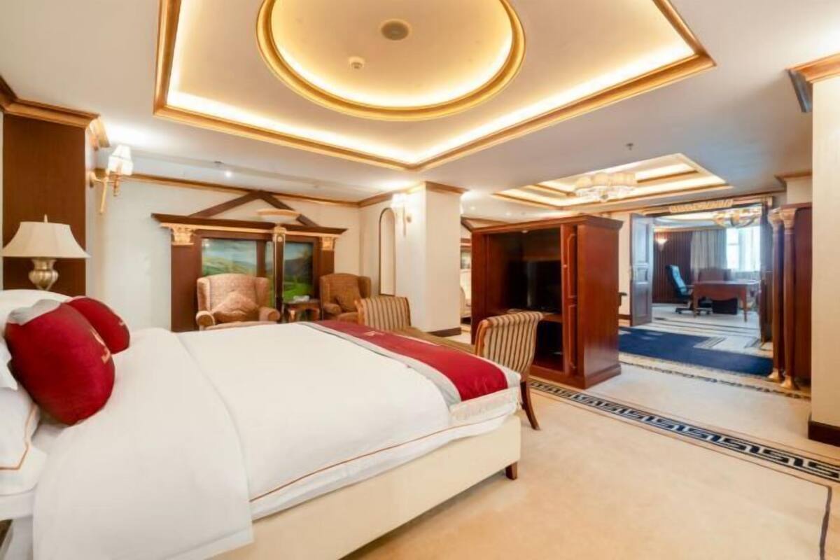Une chambre d’hôtel avec un grand lit, une armoire en bois, un bureau et une vue sur l’extérieur.