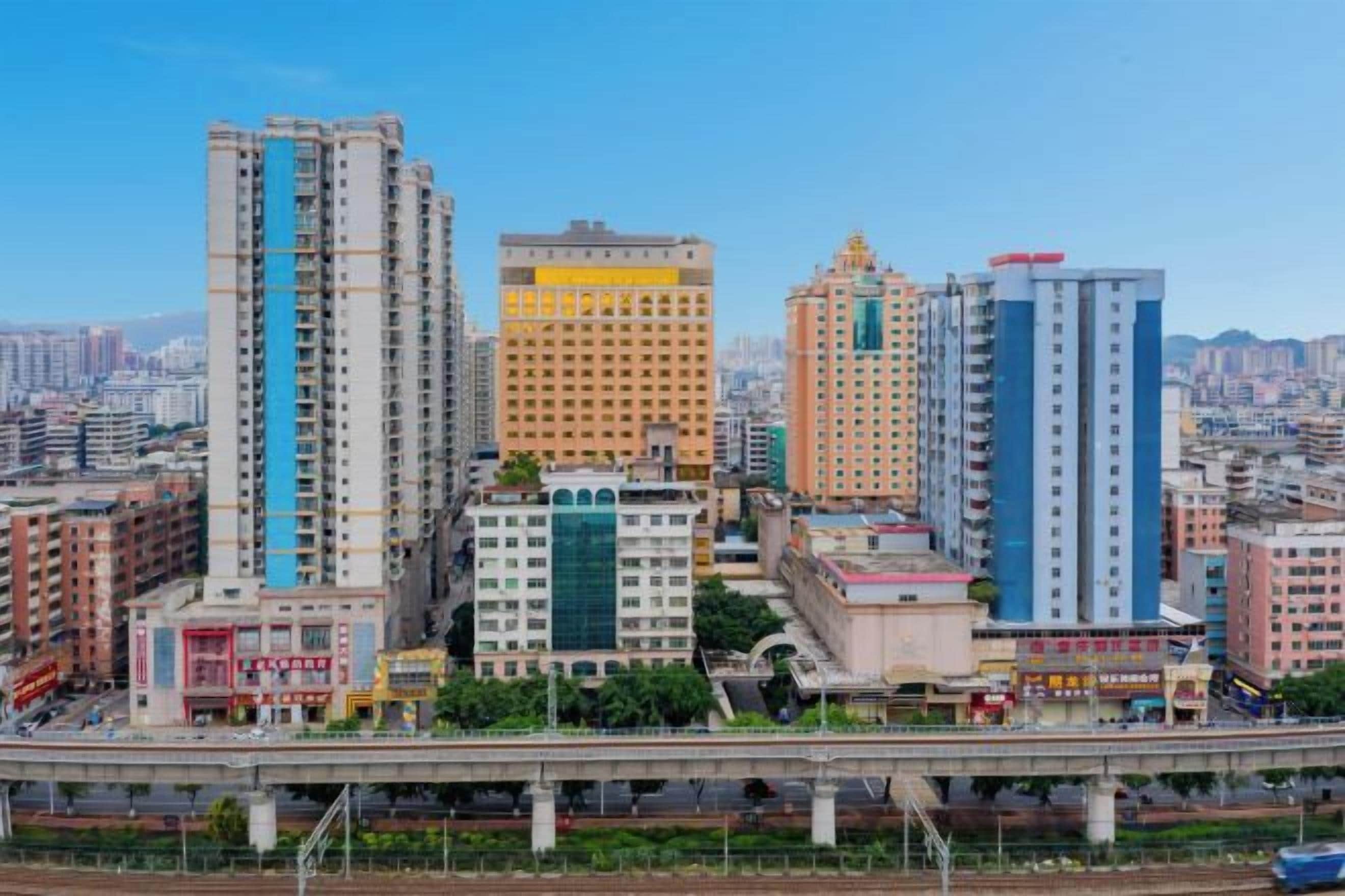 A cityscape with multiple high-rise buildings, a bridge, and a clear sky.