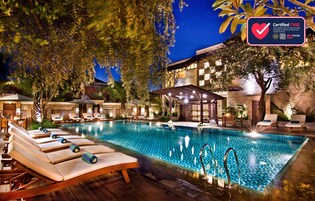 Una piscina al aire libre, sombrillas, sillones reclinables de piscina