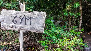 A wooden sign with the word "GYM" in black letters.