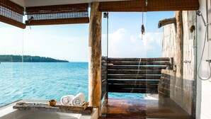 A spa area with a wooden deck, a bathtub, and a view of the sea. - Song Saa Private Island (Koh Ouen)