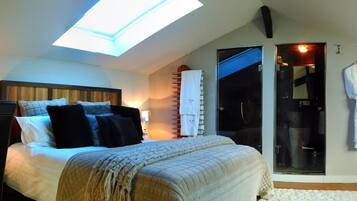 Une chambre à coucher comprenant un lit, une table de chevet, une lampe, une fenêtre et une porte-fenêtre coulissante donnant sur une salle de bain.