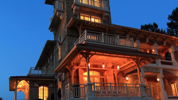 Un grand immeuble à étages, doté d’un balcon imposant et d’une façade en pierre.